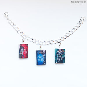 Three A Court of Thorns and Roses series miniature books on a charm bracelet